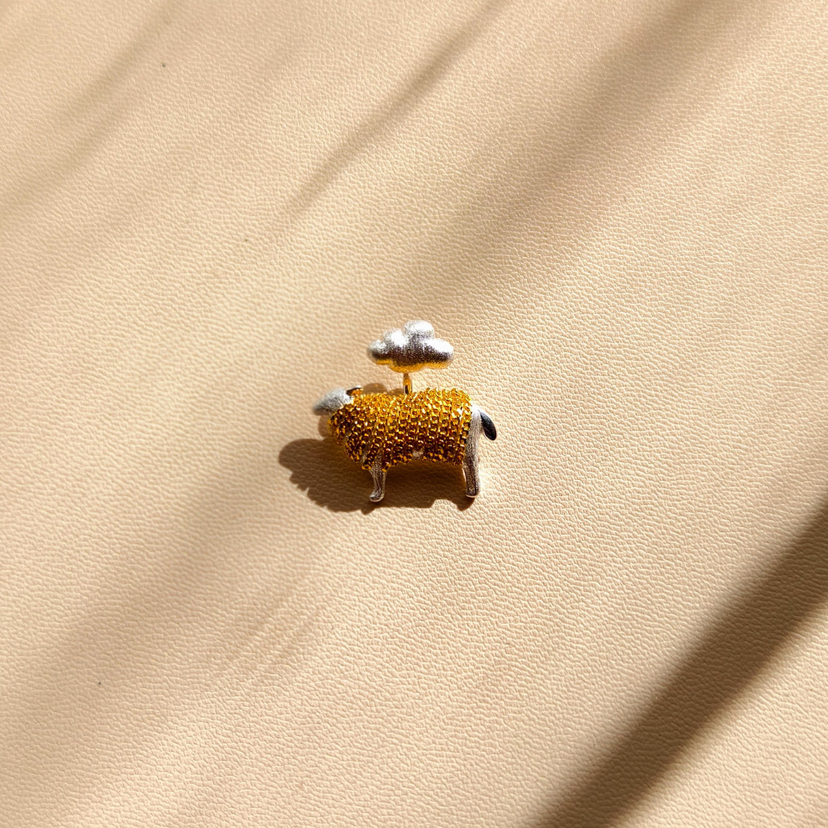 Side view of sterling silver lamb pendant with a cloud and gold-coloured chain tassels