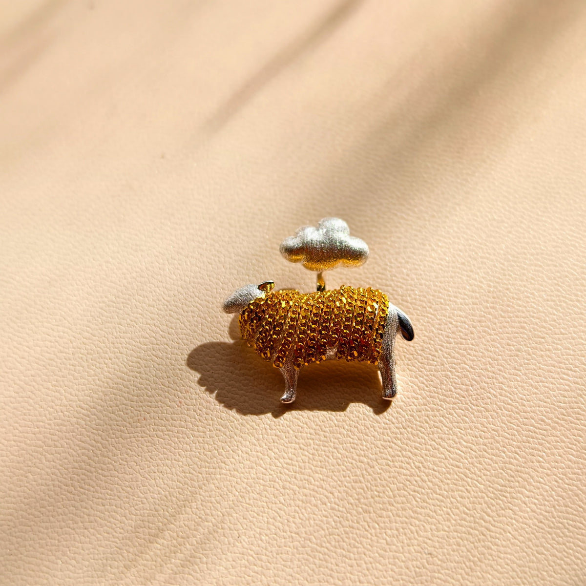 Close-up of cloud and lamb pendant with gold-coloured tassels
