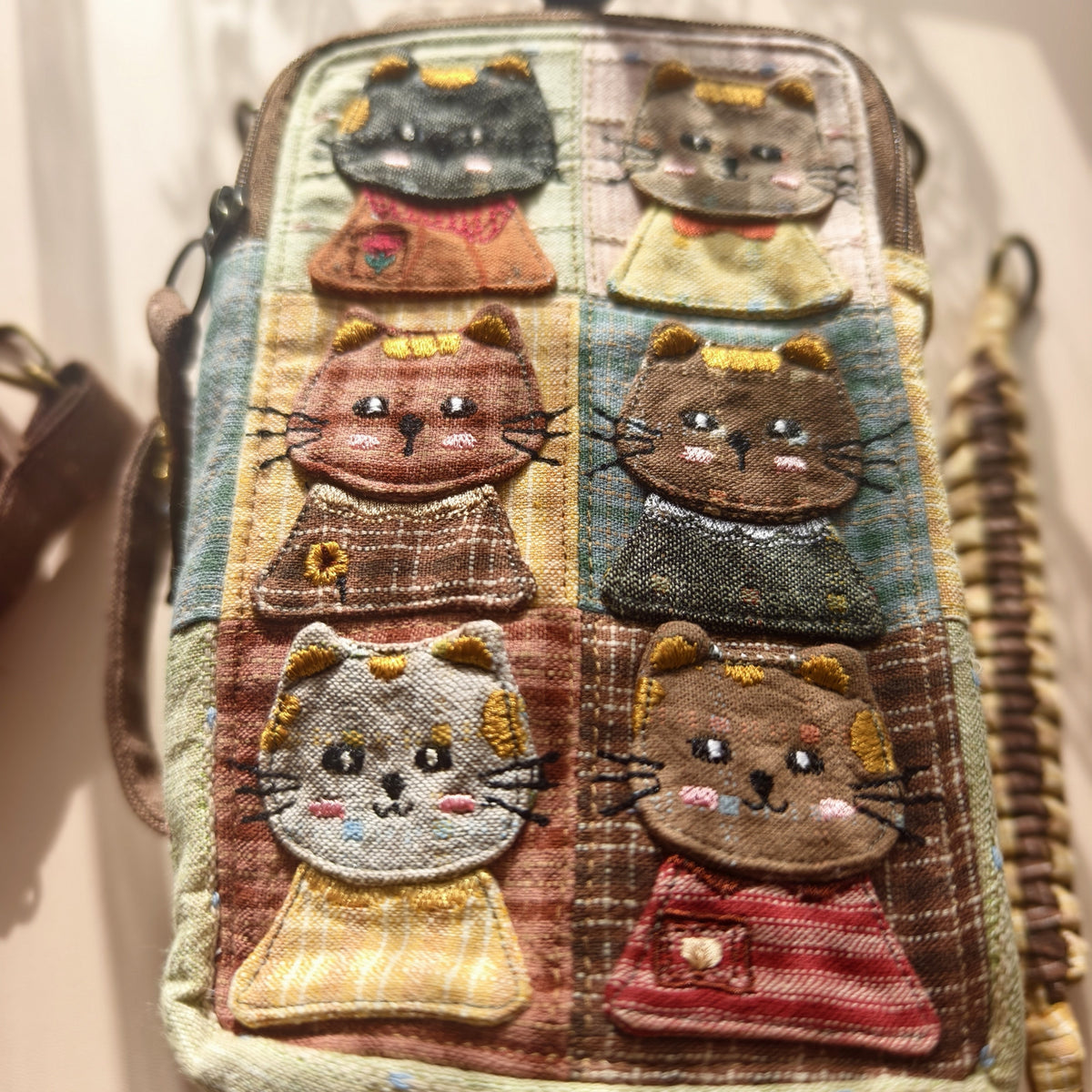 Close-up of six cat appliqués and embroidered facial details