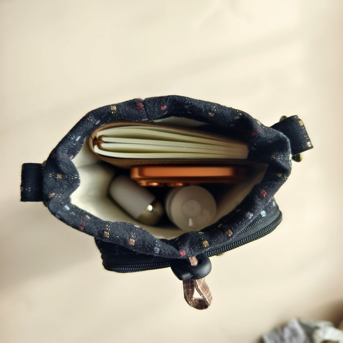 Actual drawstring compartment holding everyday essentials; contents not included