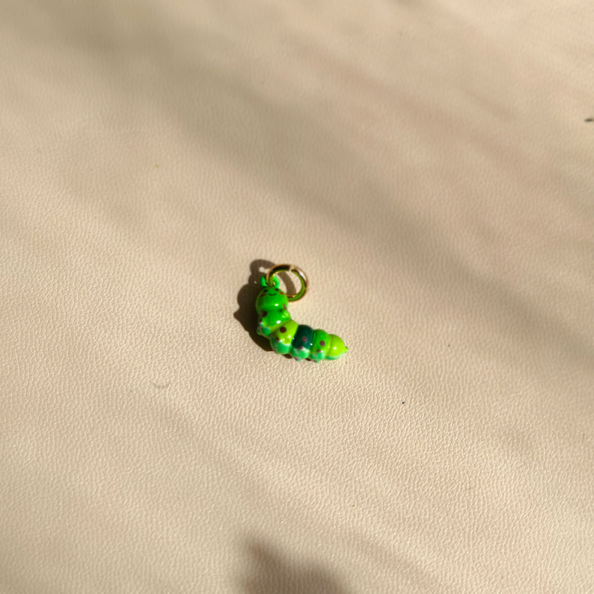 Actual green Clover Caterpillar copper charm with purple spots and gold-tone attachment ring