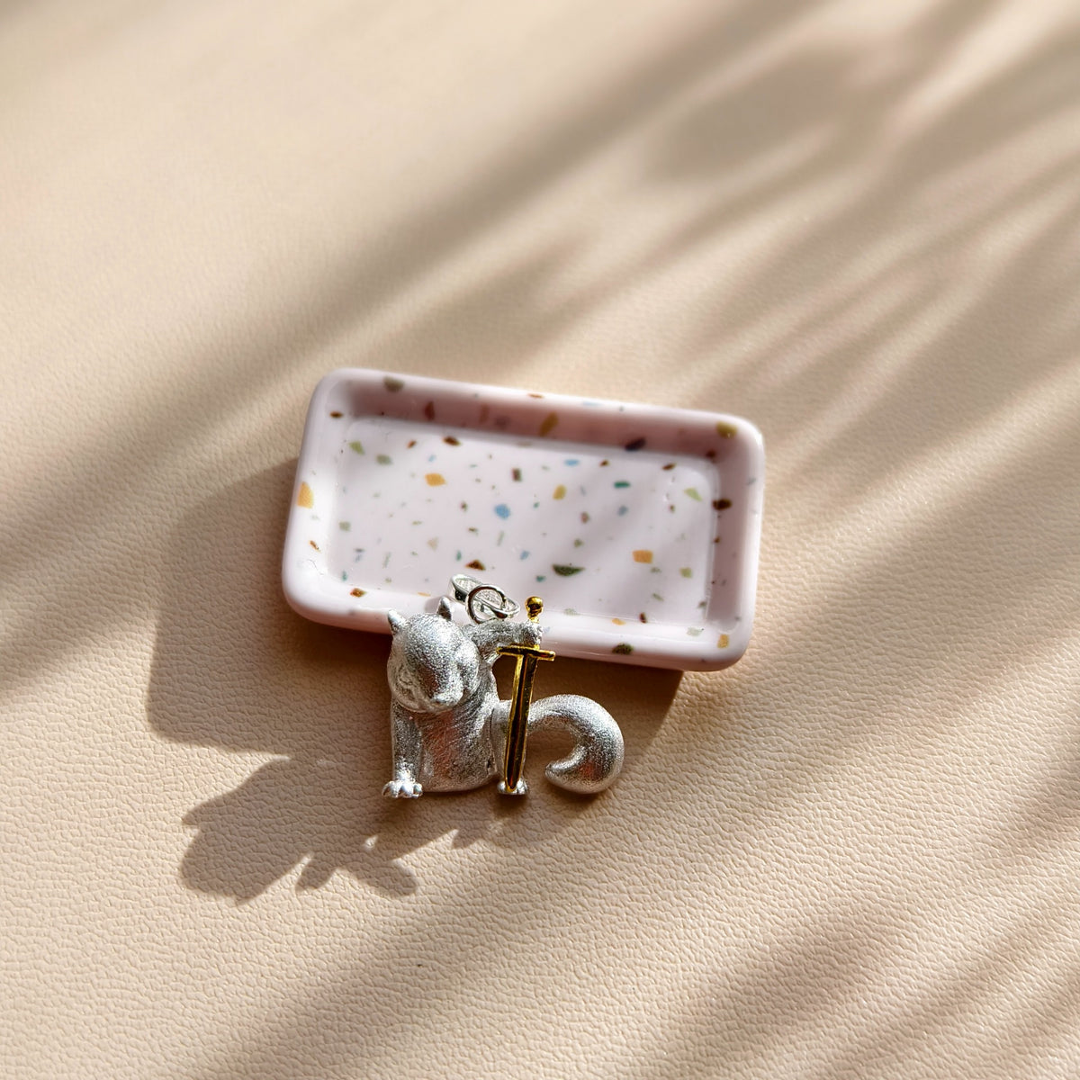 S925 sterling silver Warrior Squirrel pendant displayed beside a pale pink tray